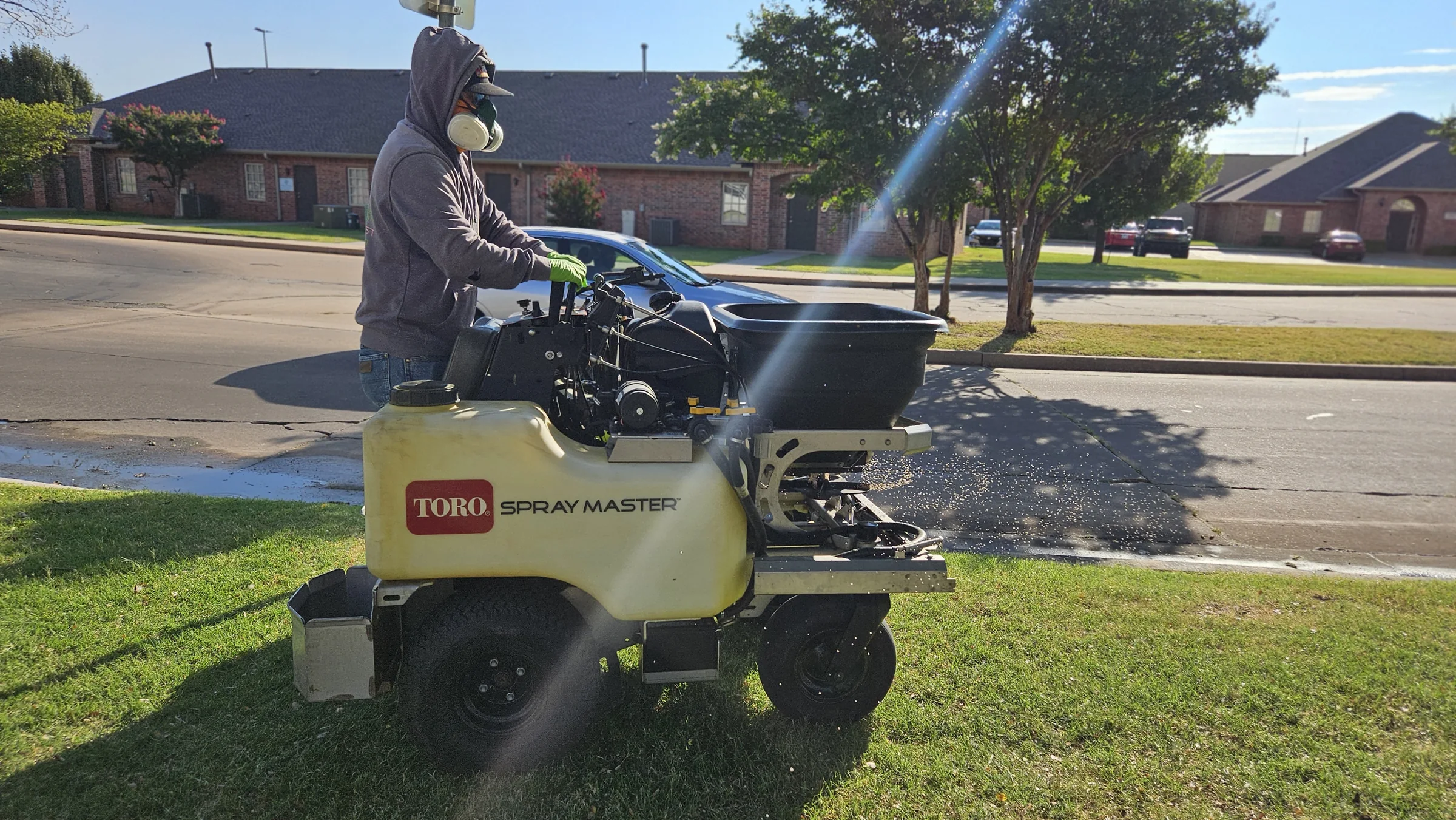 Lawn technician operating riding application equipment on a residential lawn