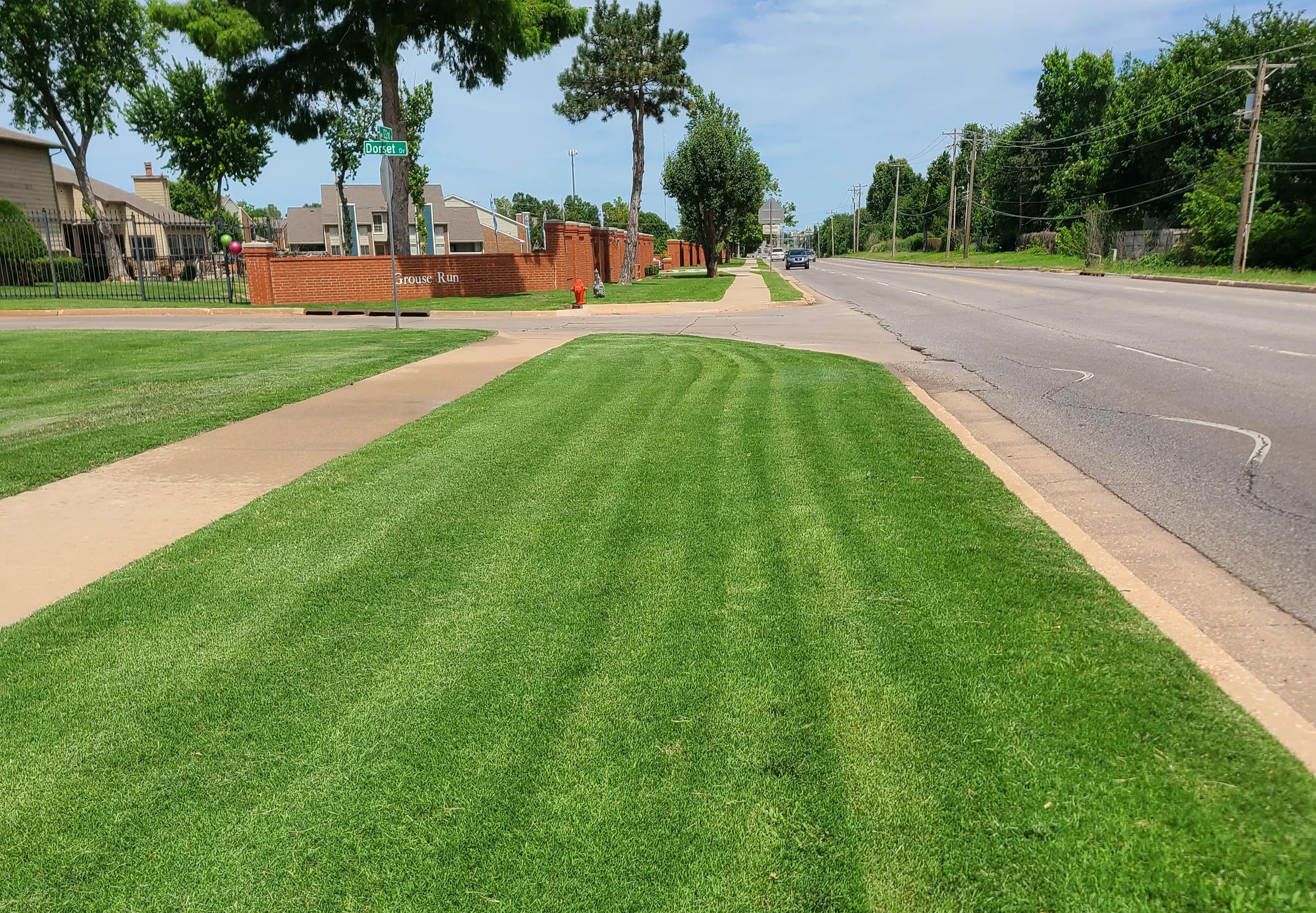 Striped green turf along a maintained Oklahoma property